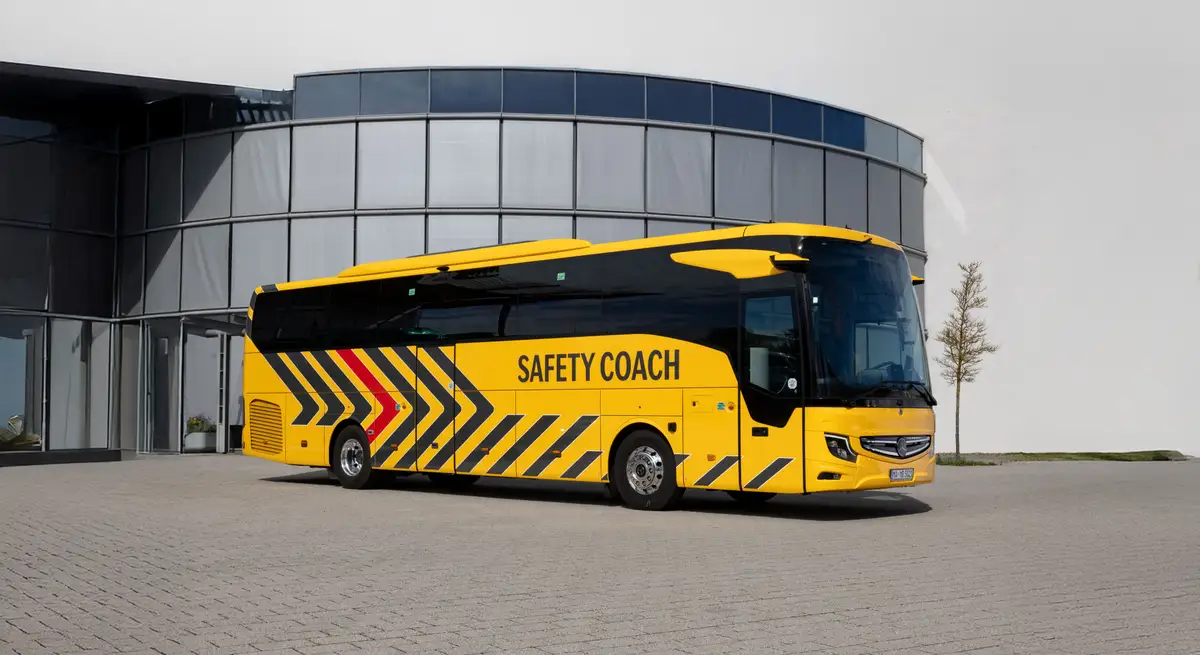 Daimler Safety Coach Reisebus vor modernem Gebäude