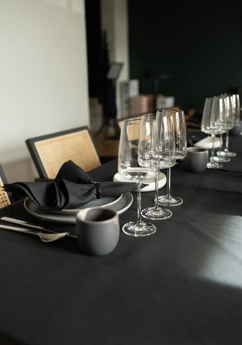 Weingläser auf dunkel eingedeckter Tafel im UnternehmerQuartier
