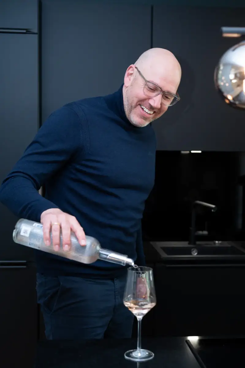 Gastgeber schenkt Wein ein im UnternehmerQuartier