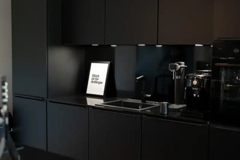 Designküche mit Kunstdruck „Glück ist für Anfänger" im UnternehmerQuartier